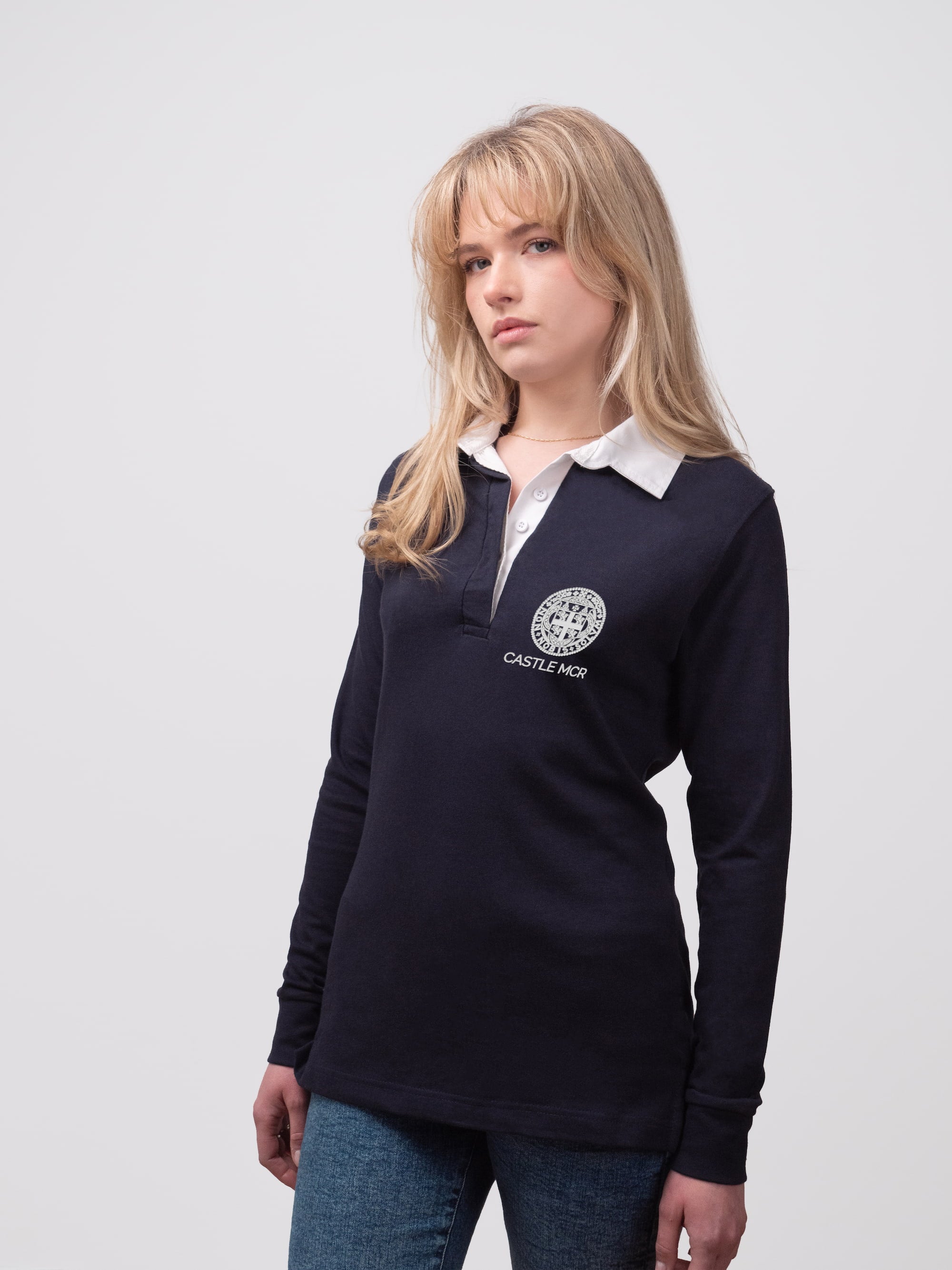 Student wearing a navy Castle MCR College rugby shirt with embroidered crest