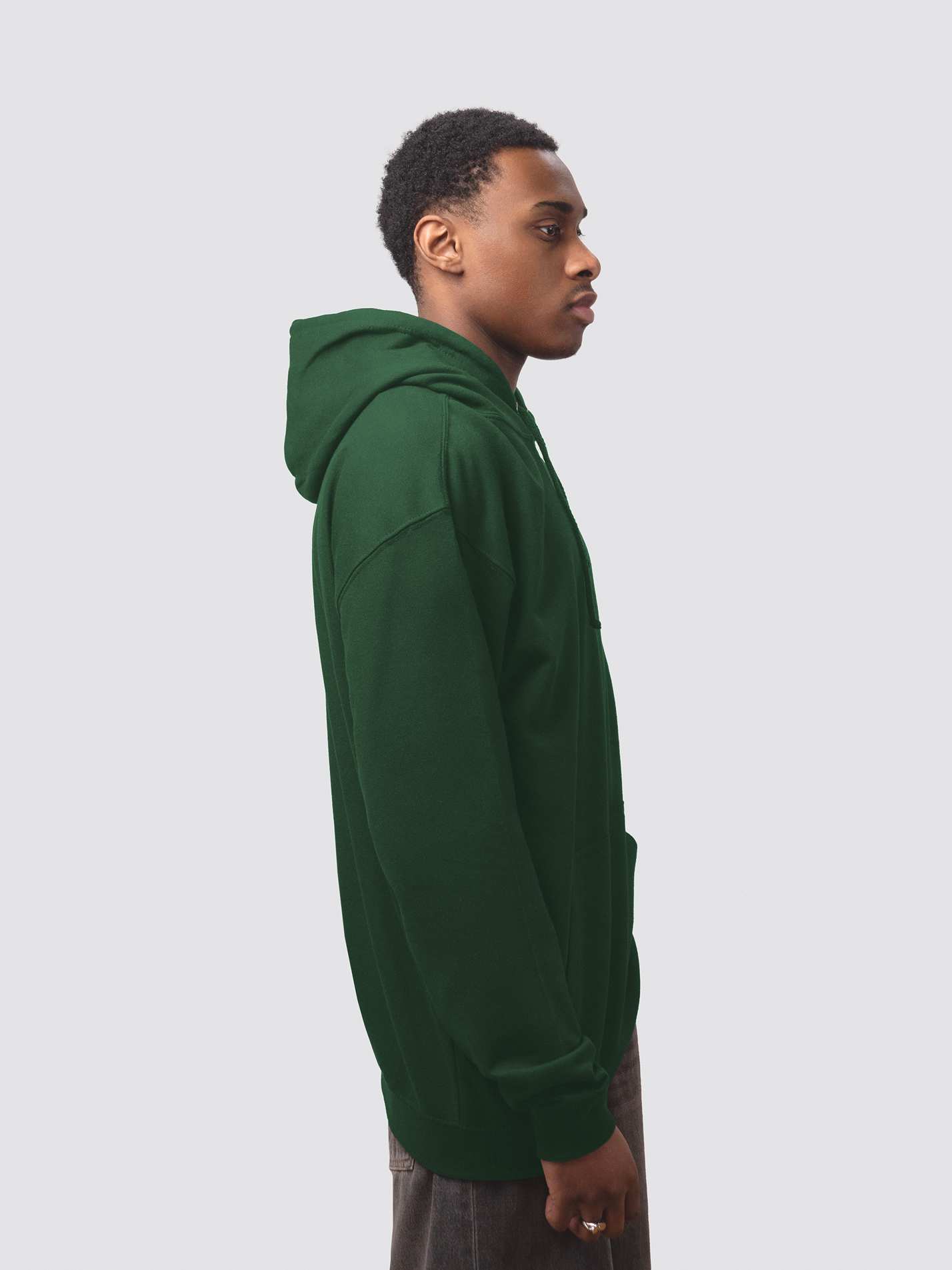The side of a bottle green hoodie, worn by a male student model