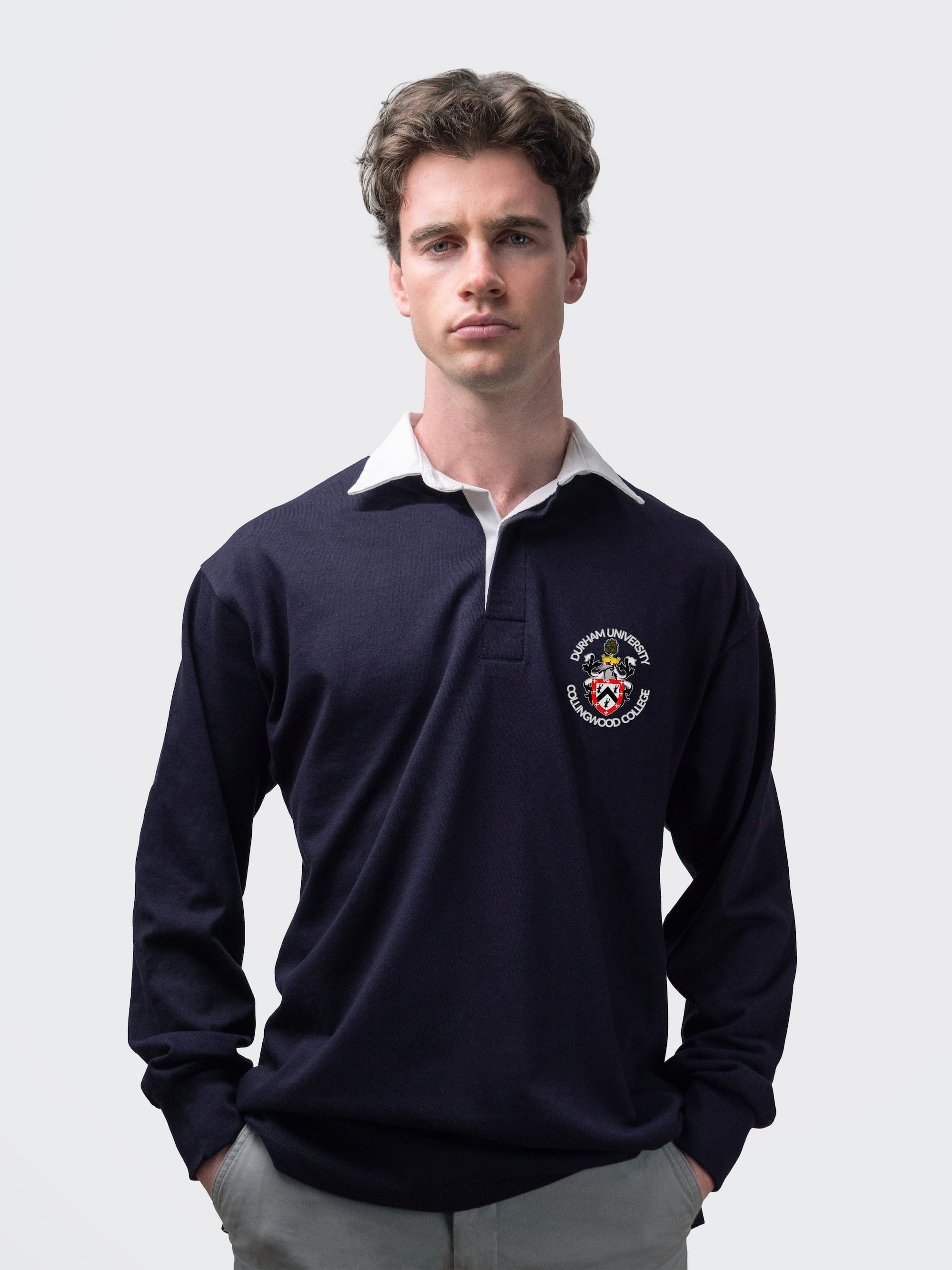 Collingwood student wearing an embroidered mens rugby shirt in navy