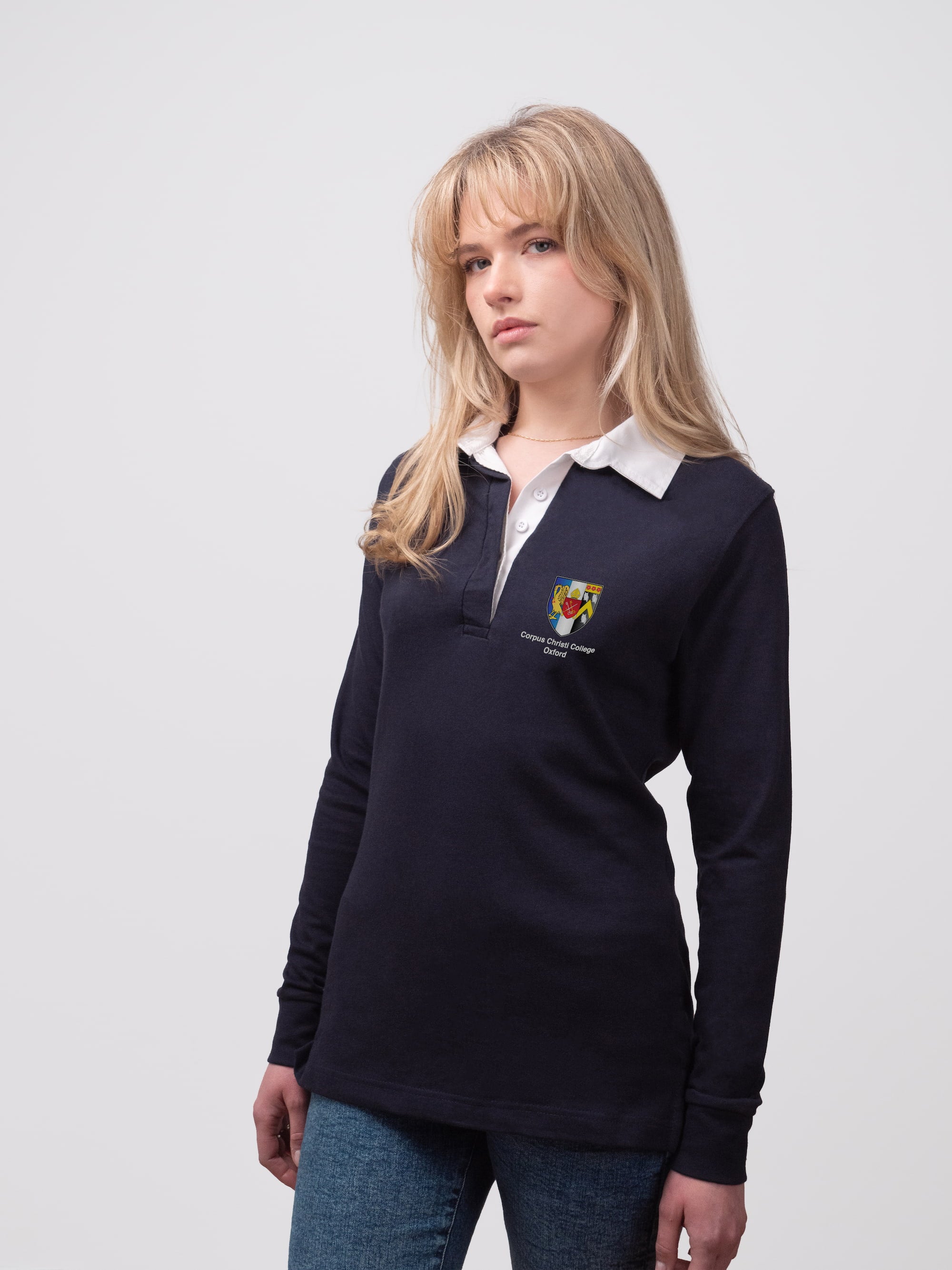 Student wearing a navy Corpus Christi College rugby shirt with embroidered crest