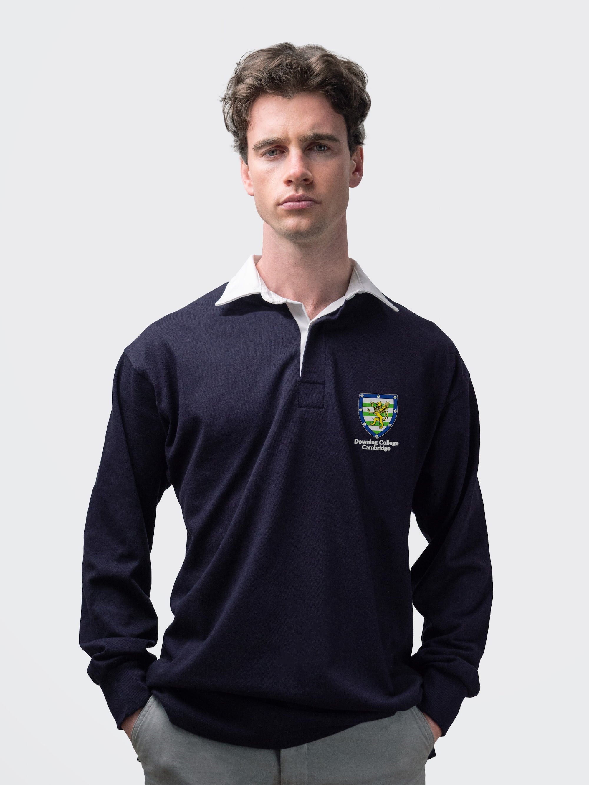Downing student wearing an embroidered mens rugby shirt in navy