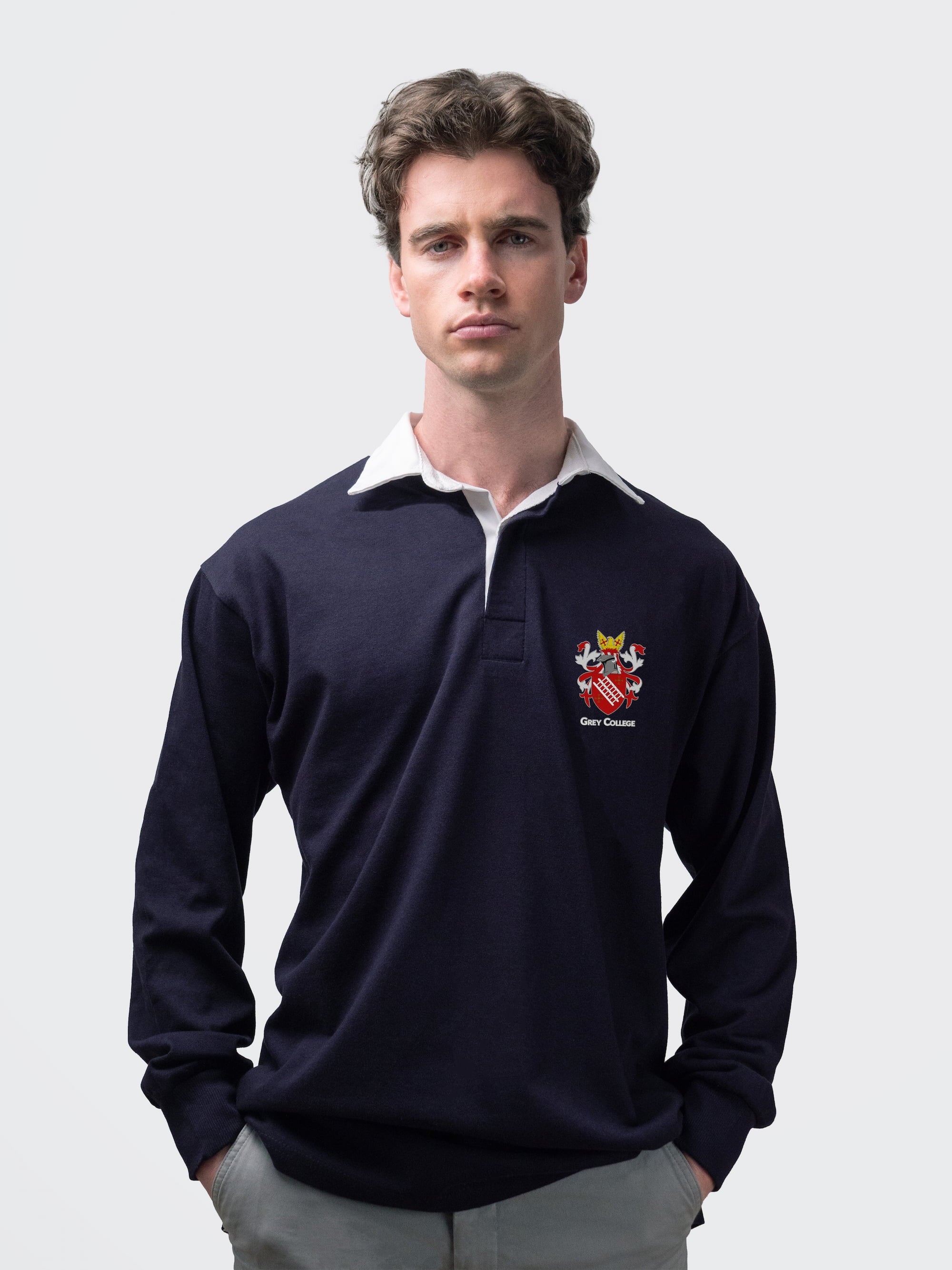 Grey College student wearing an embroidered mens rugby shirt in navy