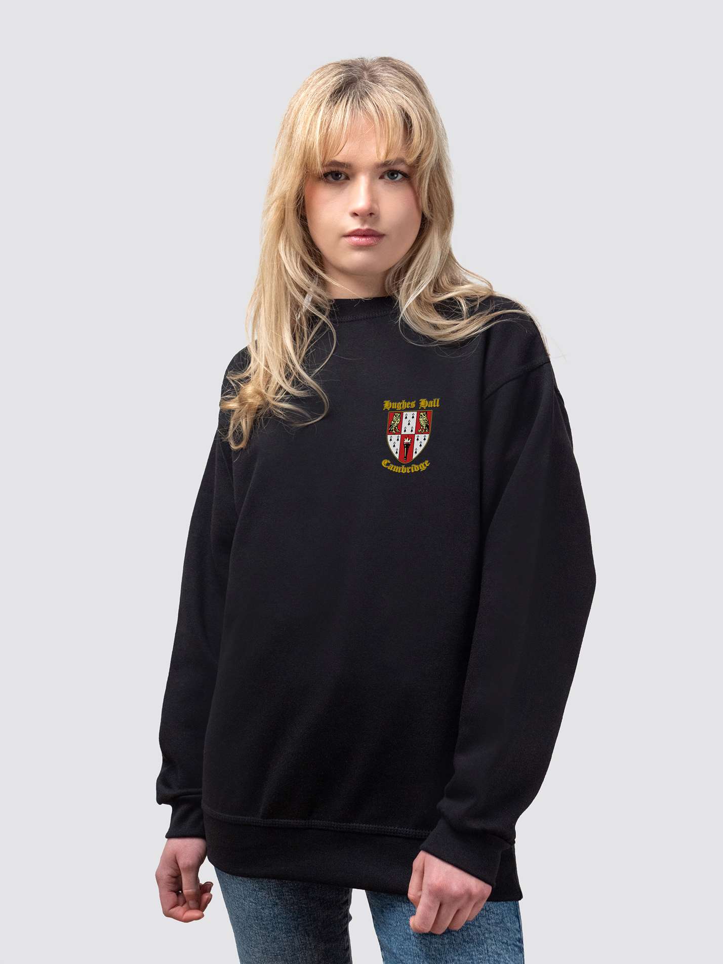 Hughes Hall crest on the front of a black, crew-neck sweatshirt
