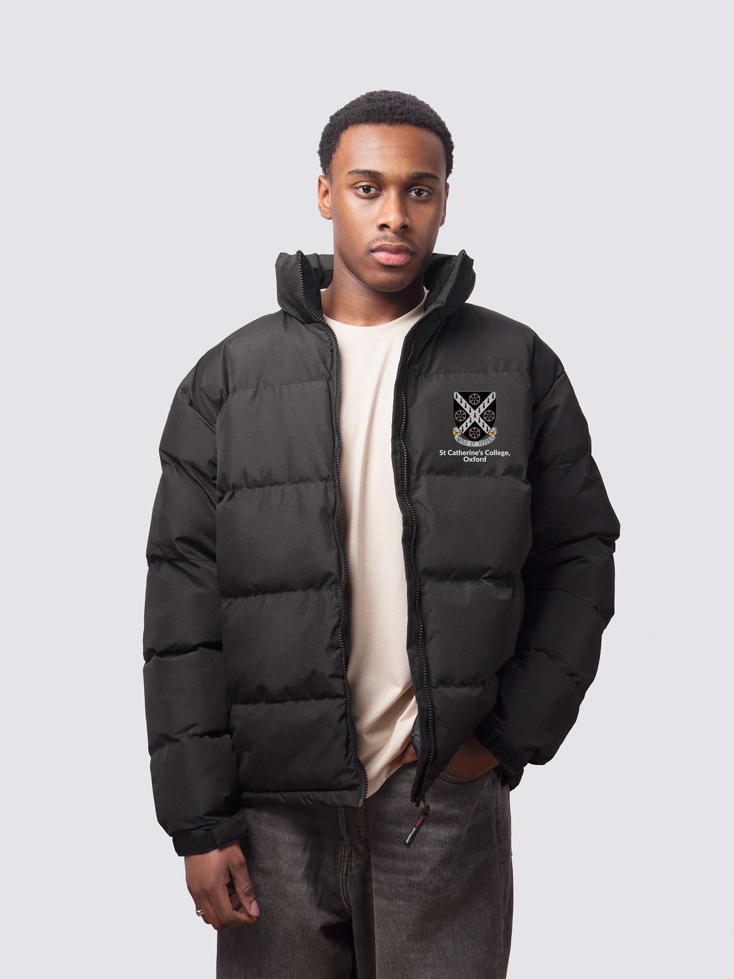 A student wearing a black college puffer jacket, with an embroidered left-chest logo