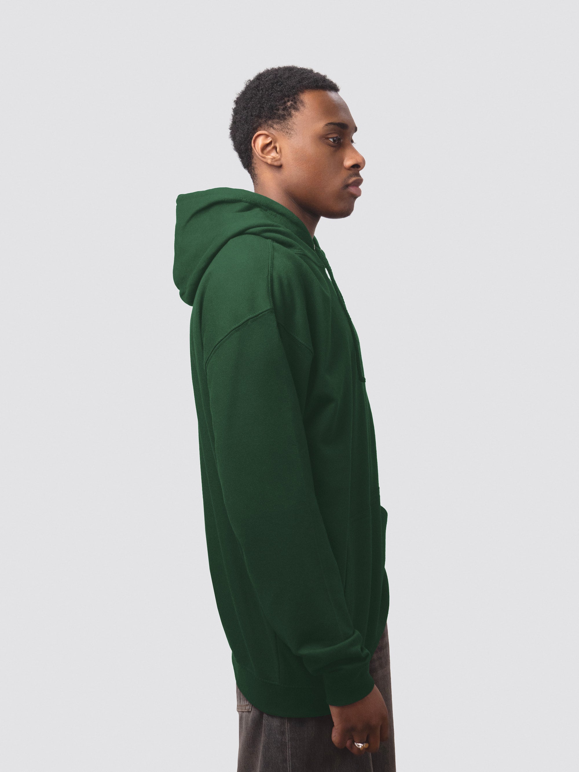 The side of a bottle green hoodie, worn by a male student mode