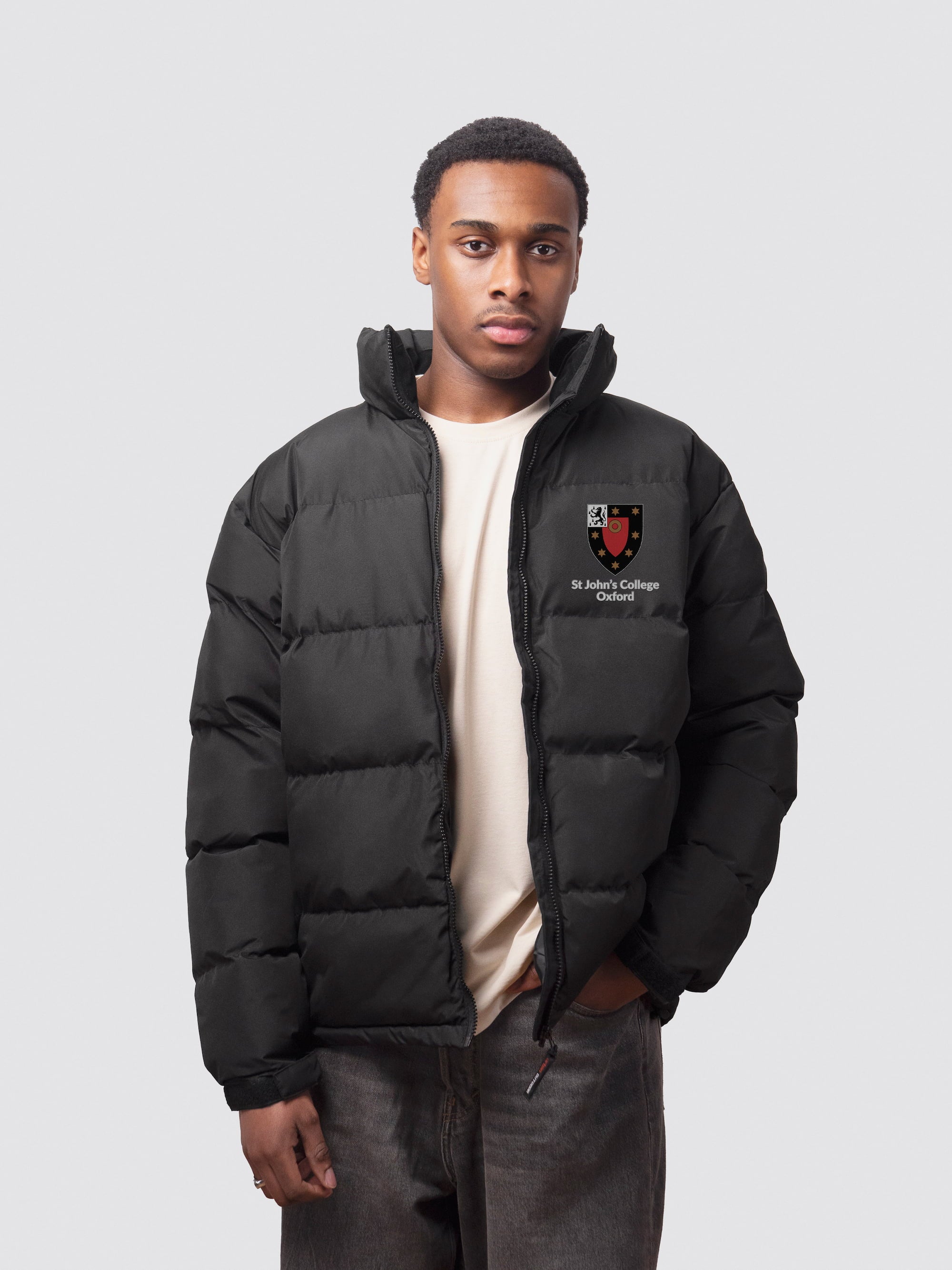 A student wearing a black college puffer jacket, with an embroidered left-chest logo