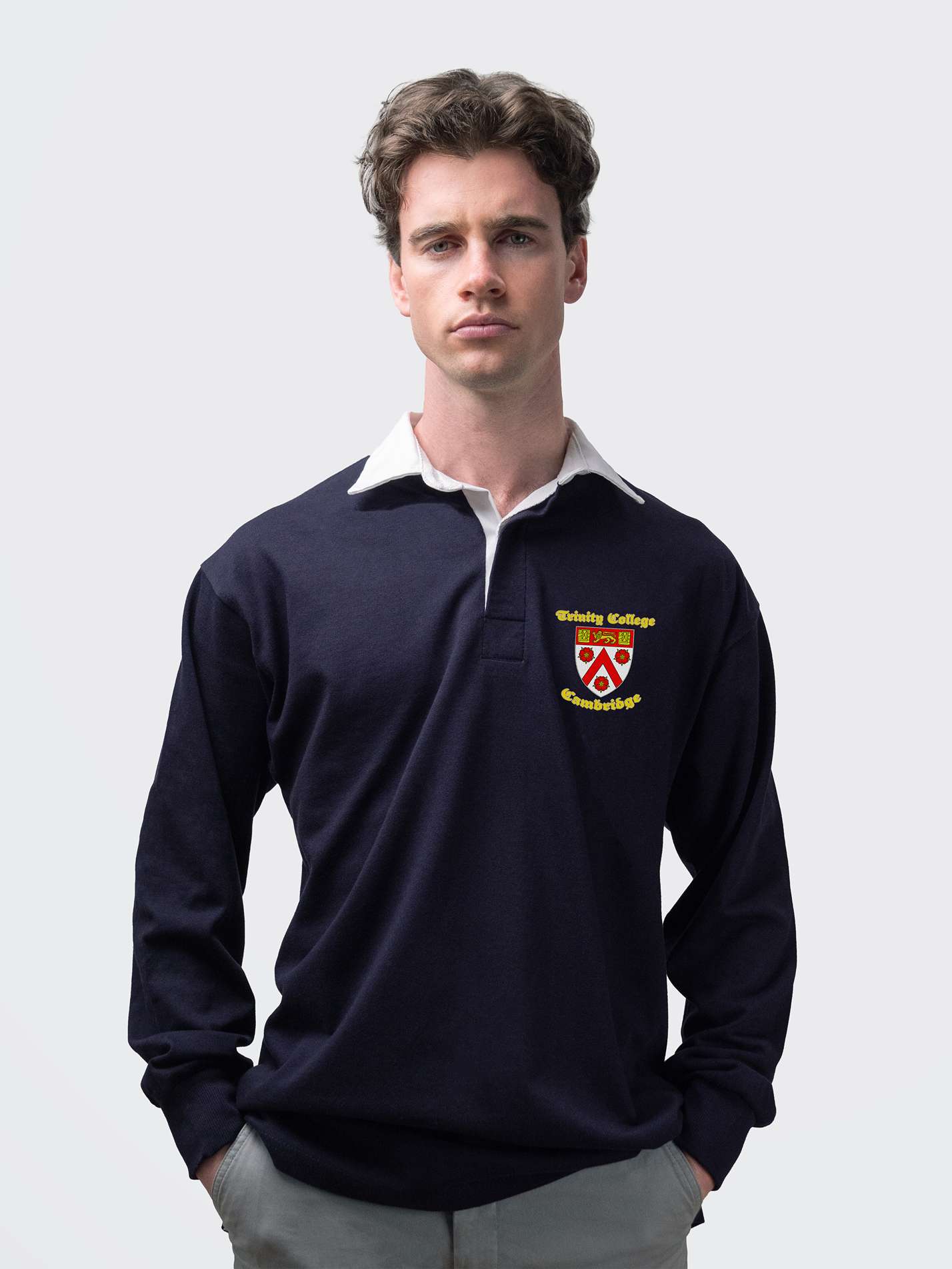 Trinity student wearing an embroidered mens rugby shirt in navy